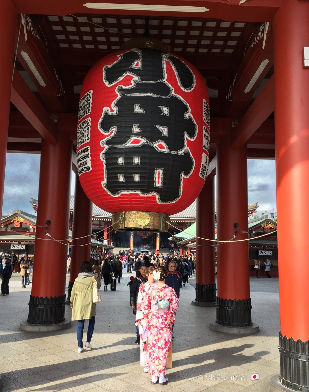 Rote Papierlaterne mit der Aufschrift Kobunachō unter dem Hōzōmon-Tor, davor eine Frau im rosa Kimono