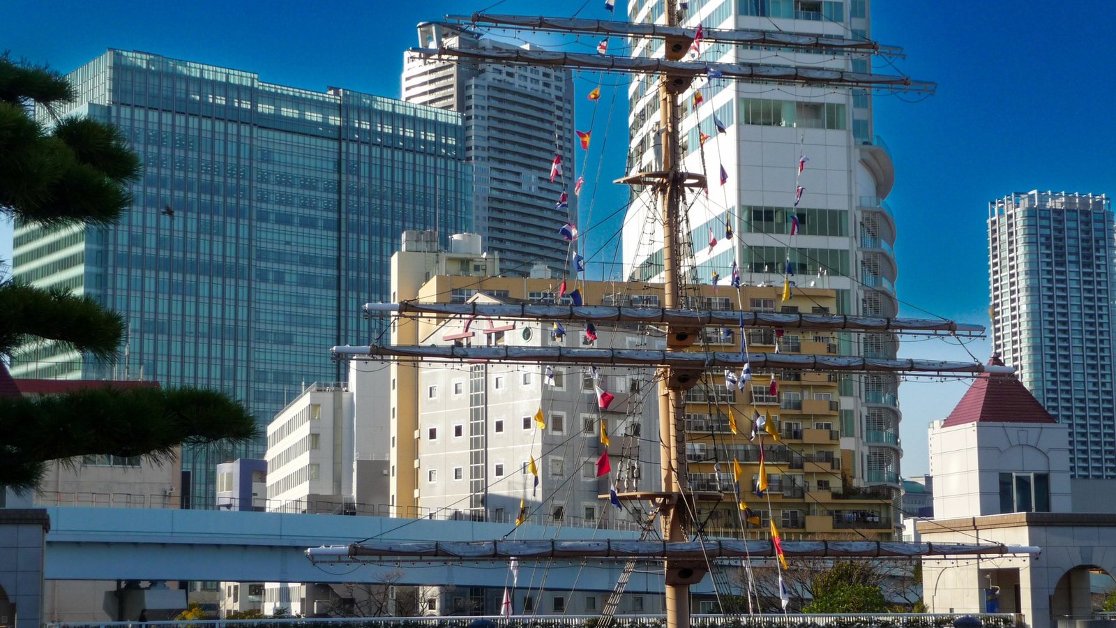 Mast mit bunten Signalflaggen vor Hochhäusern am Takeshiba-Passagierterminal