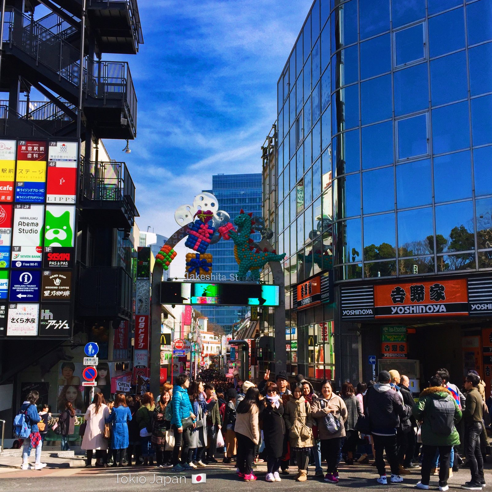 Eingangstor der Takeshita-dōri in Harajuku mit Ballonfiguren, davor eine dichte Menschenmenge