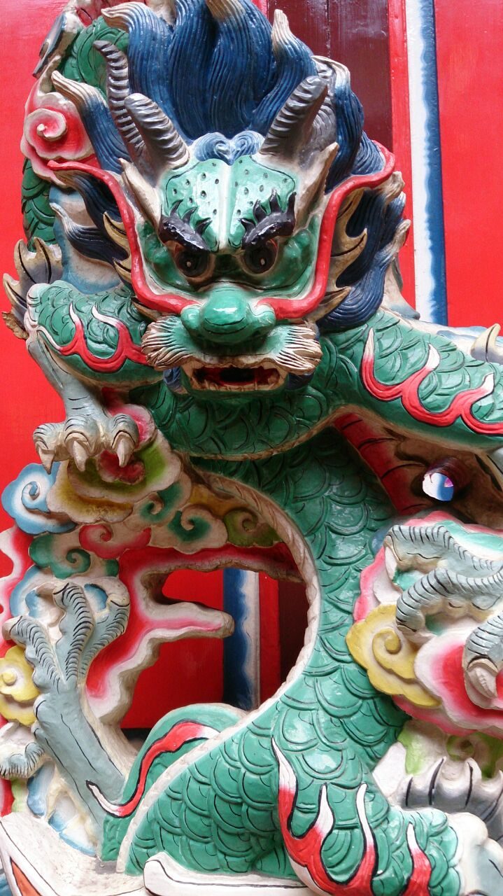 Farbenprächtige Drachenskulptur in Grün und Rot an einem chinesischen Tempel