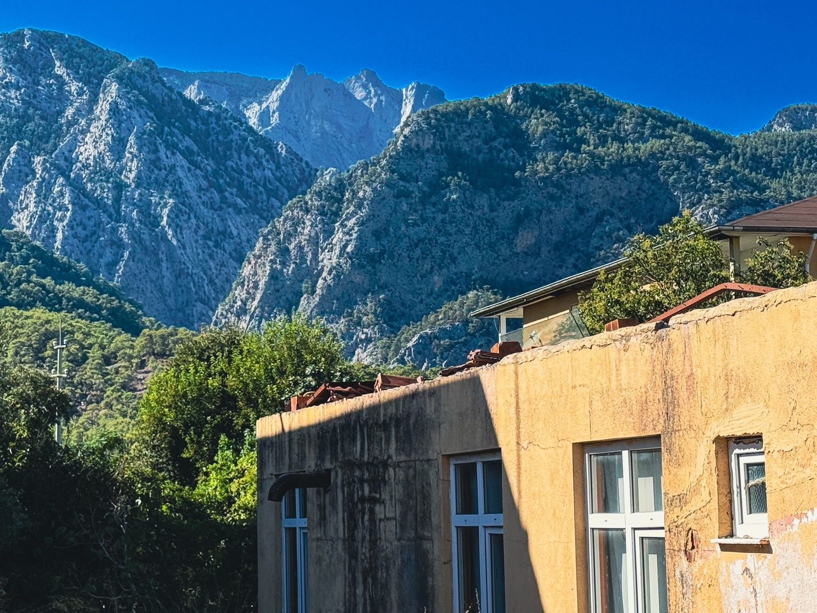 Blick vom Balkon auf die schroffen Taurus-Berge über den Dächern von Beldibi