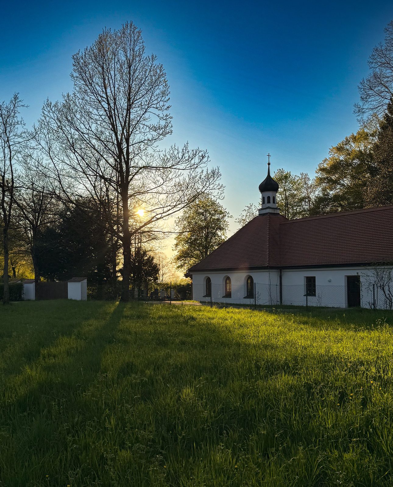 Kleine Kapelle mit Zwiebelturm im goldenen Abendlicht bei Bad Heilbrunn