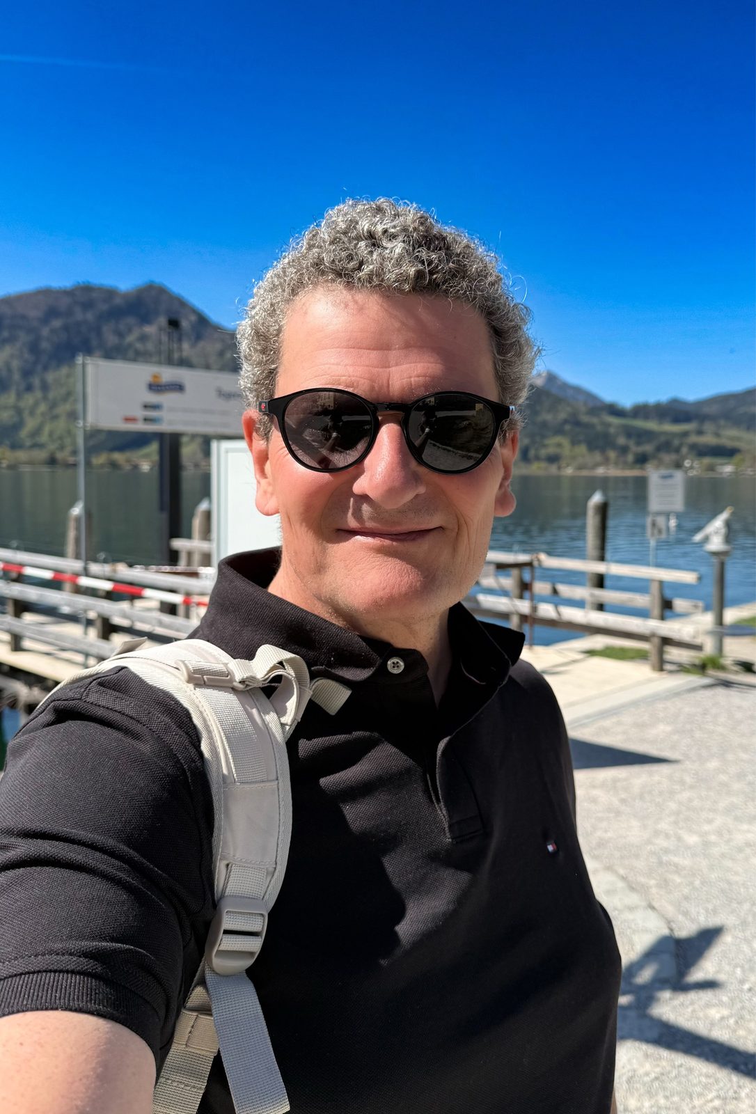 Torsten Fink als Selfie am Bootssteg des Tegernsees mit Bergen im Hintergrund