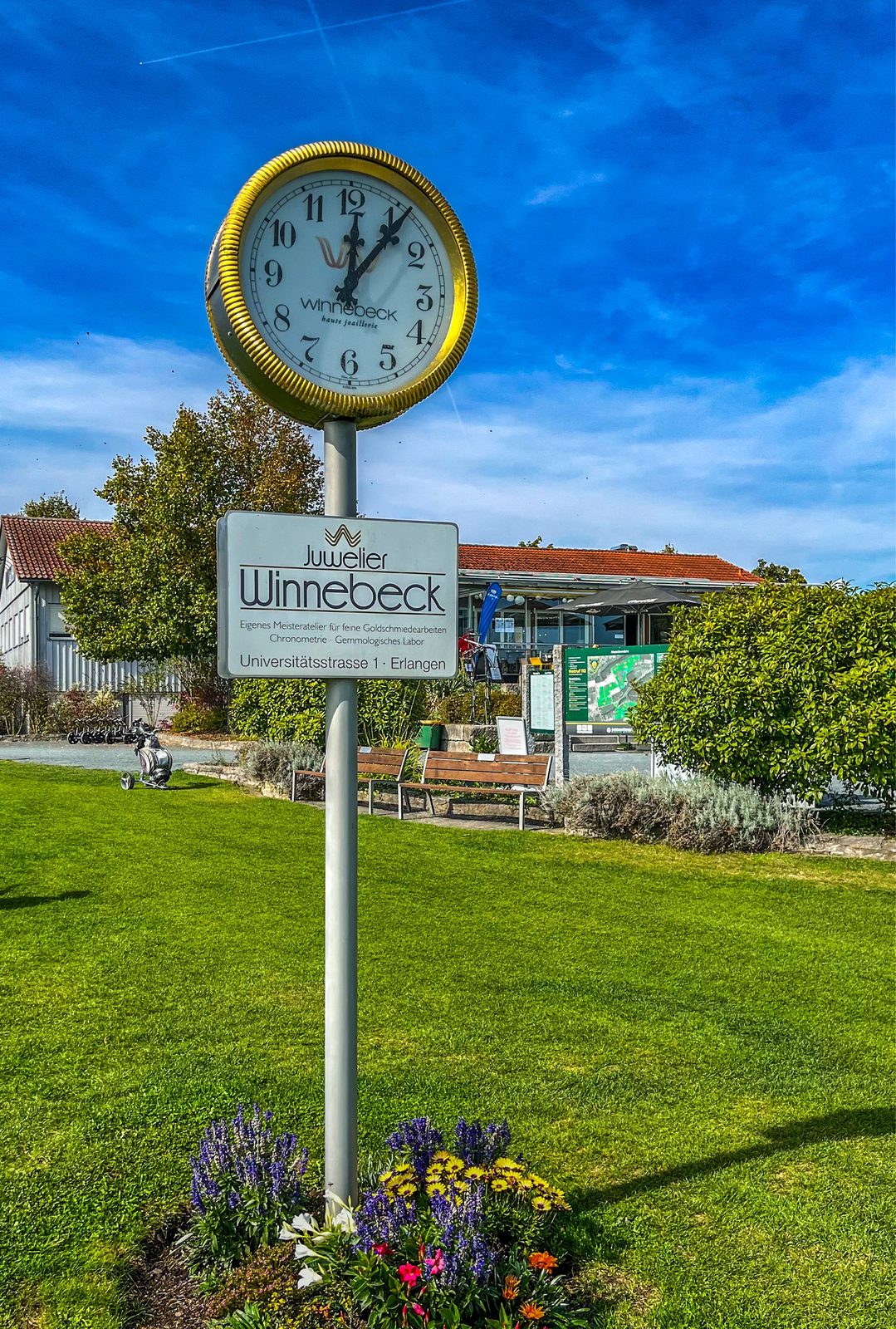 Goldene Standuhr des Juweliers Winnebeck am ersten Abschlag des Golf-Club Herzogenaurach mit Blumenbeet