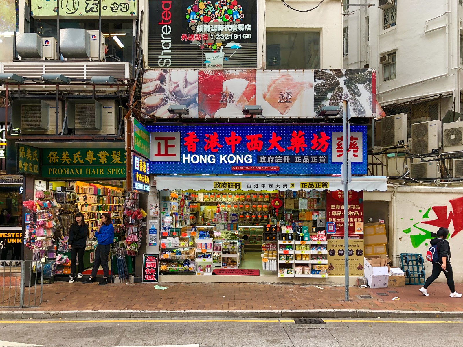Chinesisch-westliche Apotheke mit großer Leuchtreklame und Werbung für Abalone, Vogelnester und Fischmagen