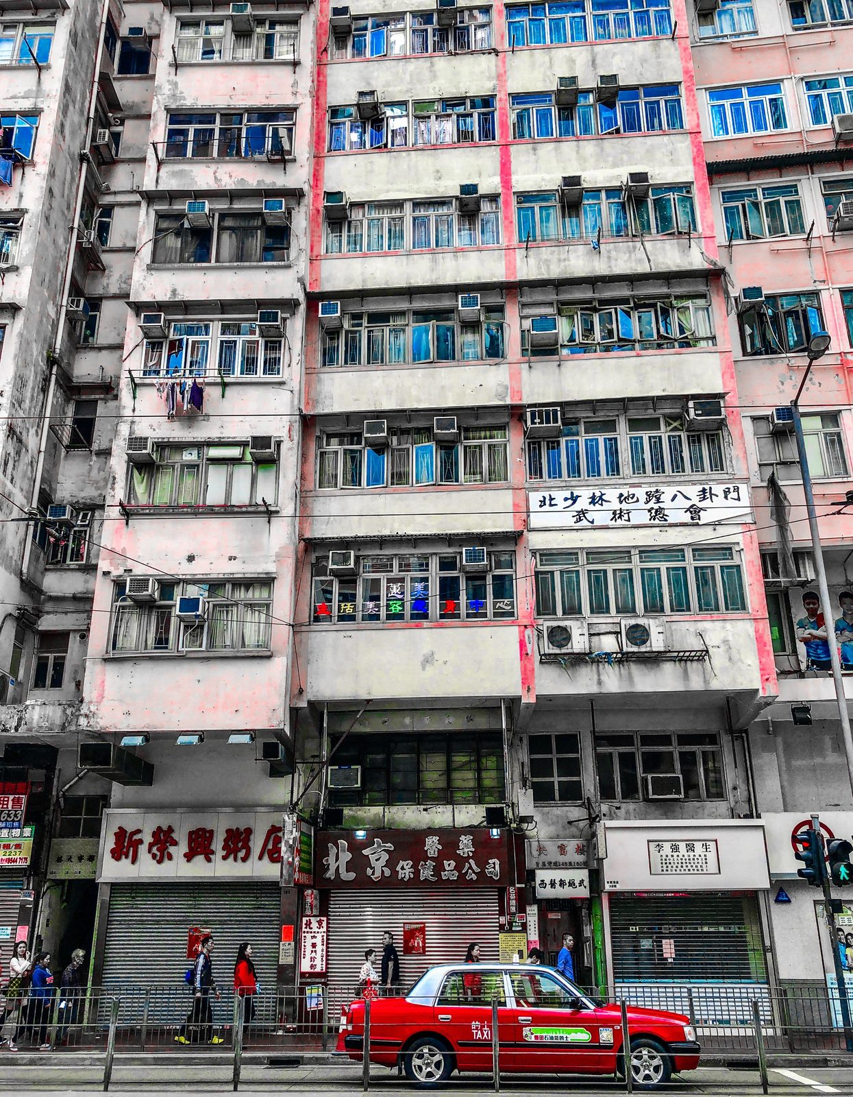 Rotes Taxi vor Kompositfassade in Hongkong