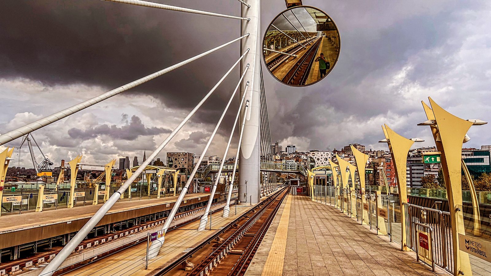 Verkehrsspiegel an der Haliç-Metrostation, darin der Fotograf, die Gleise und ein dramatischer Wolkenhimmel