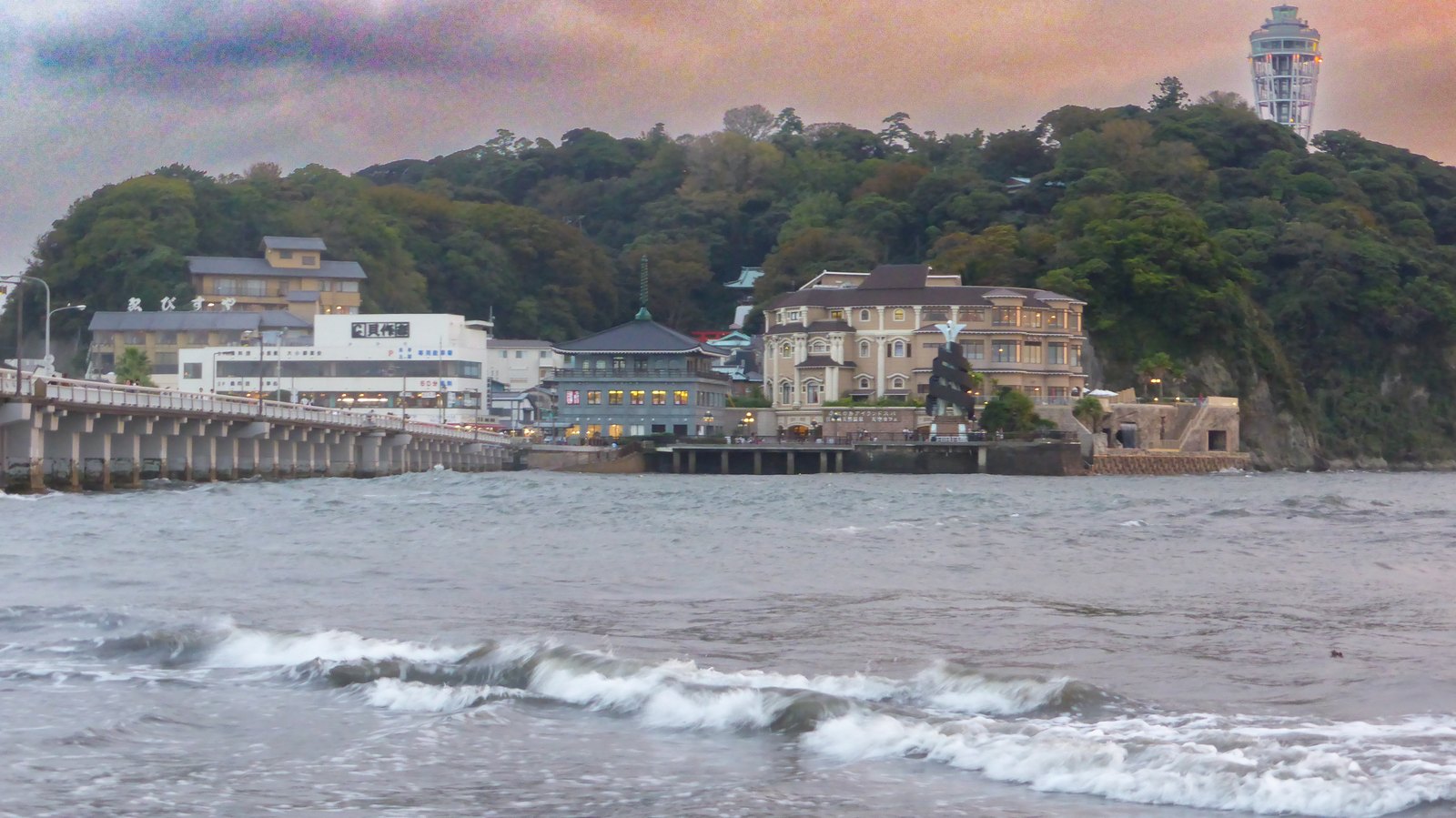 Enoshima im Abendlicht mit Steg und der gläsernen Aussichtskonstruktion über den Gewächshausruinen