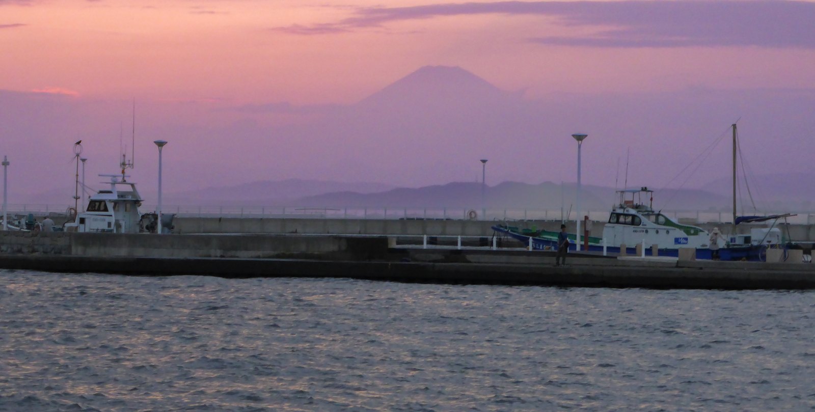 Der Fuji zeigt sich zwischen Wolken und Dunst am Horizont