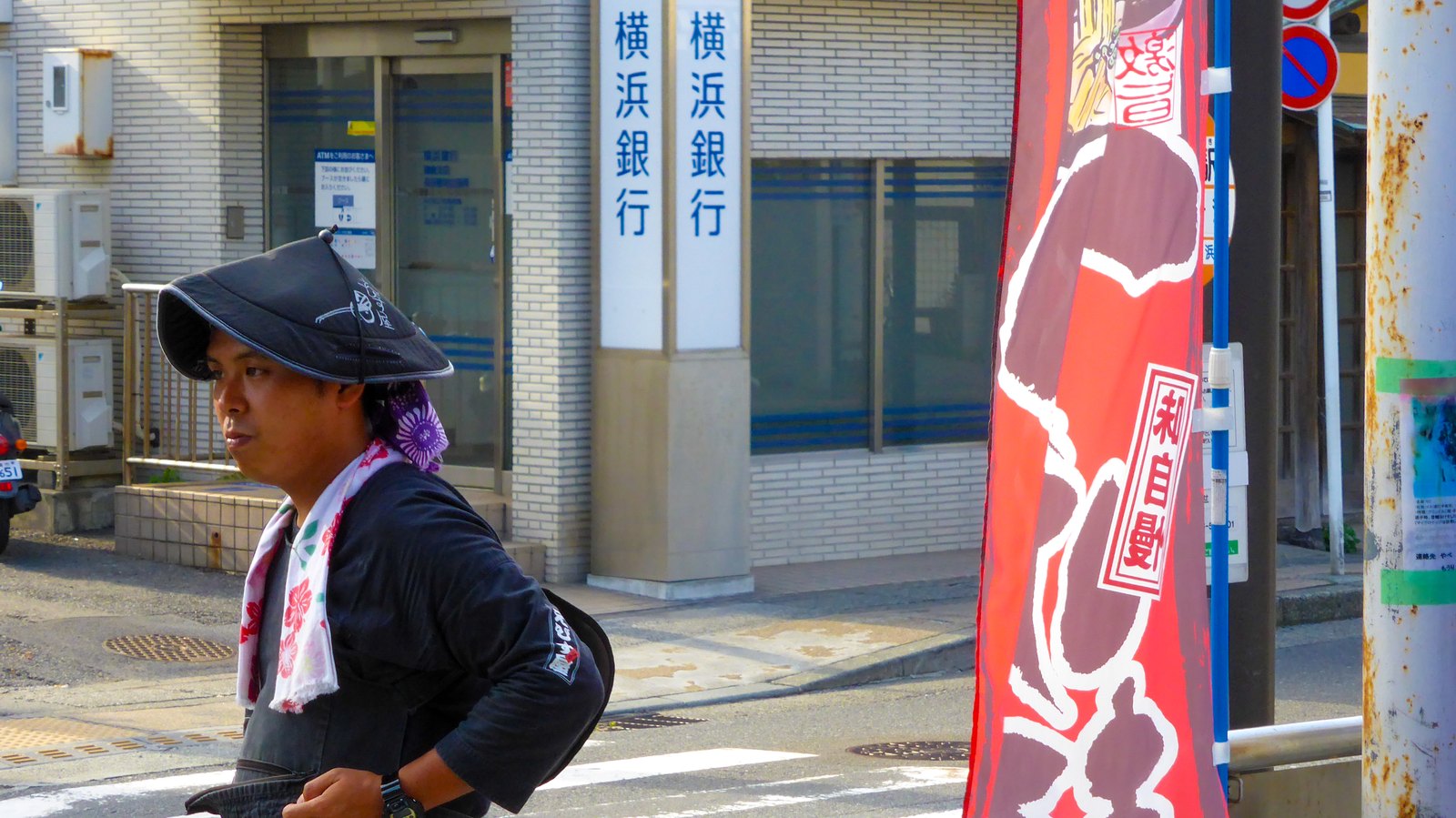 Mann mit traditioneller japanischer Kopfbedeckung auf einer Straße in Kamakura