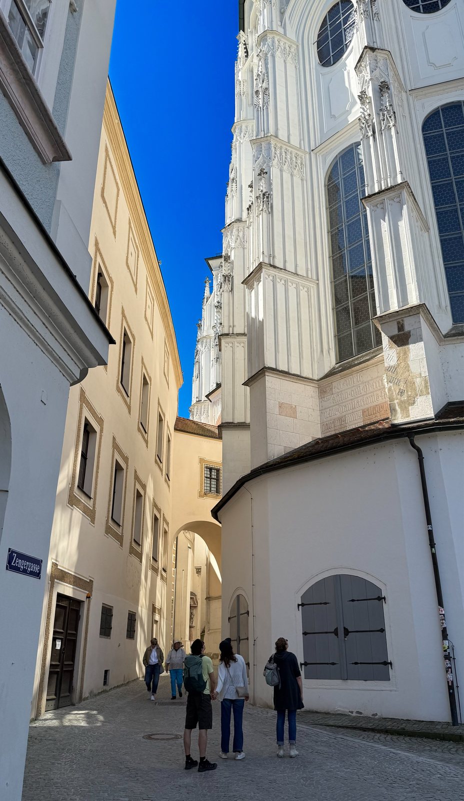 Enge Zengergasse in Passau mit Blick auf die weiße Barockfassade des Doms St. Stephan