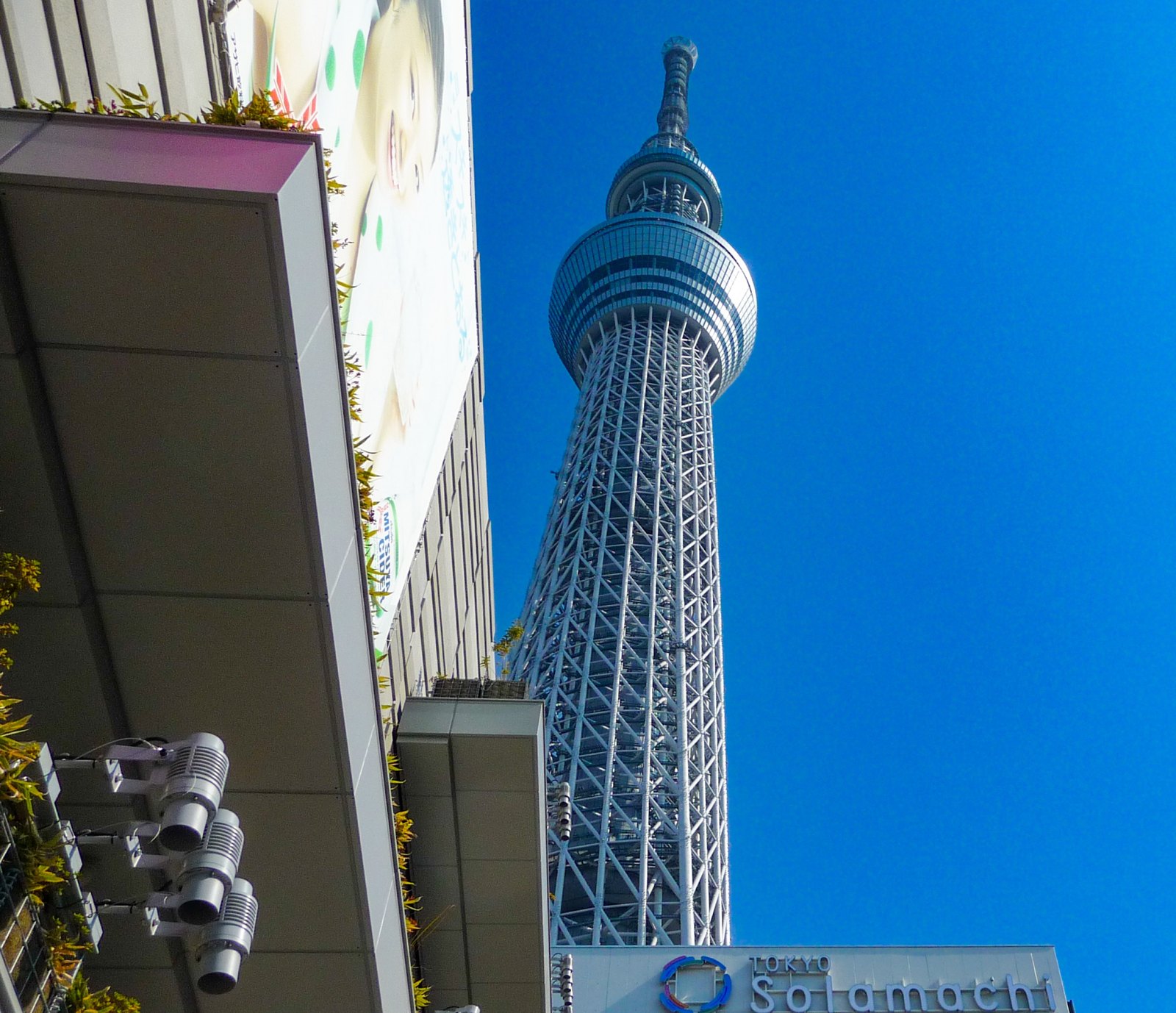 Tokyo Skytree ragt neben modernen Gebäuden des Einkaufszentrums Solamachi in den blauen Himmel